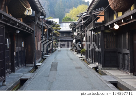 Old townscape of Takayama City, Gifu Prefecture, Japan. A sake shop decorated with cedar balls and an old house with a sense of history. Morning scene during the Takayama Spring Festival. Old townscape of Takayama City, Gifu Prefecture, Japan. A sake shop decorated with cedar balls and an old house with a sense of history. Morning scene during the Takayama Spring Festival. 134897711