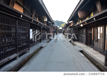 Old townscape of Takayama City, Gifu Prefecture, Japan. A sake shop decorated with cedar balls and an old house with a sense of history. Morning scene during the Takayama Spring Festival. Old townscape of Takayama City, Gifu Prefecture, Japan. A sake shop decorated with cedar balls and an old house with a sense of history. Morning scene during the Takayama Spring Festival. 134897714