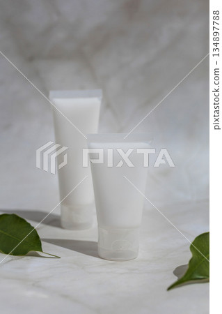 Minimalist skincare mockup with blank cosmetic tubes and green leaves on marble surface, ideal for natural beauty products, organic branding, clean cosmetics and modern wellness design. Minimalist skincare mockup with blank cosmetic tubes and green leaves on marble surface, ideal for natural beauty products, organic branding, clean cosmetics and modern wellness design. 134897788