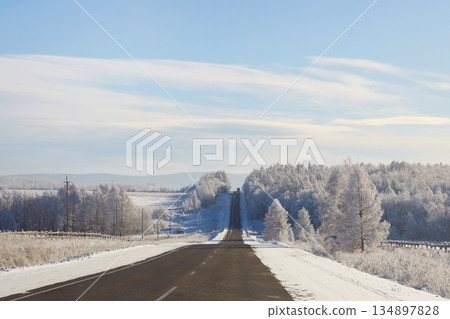 Winter driving on a snowy road with trees in a forest landscape Winter driving on a snowy road with trees in a forest landscape 134897828