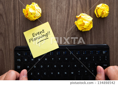 Event planning at desk with sticky note and crumpled paper Event planning at desk with sticky note and crumpled paper 134898542
