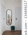 Oval mirror entry with emerald velvet stool and reflection 134899227
