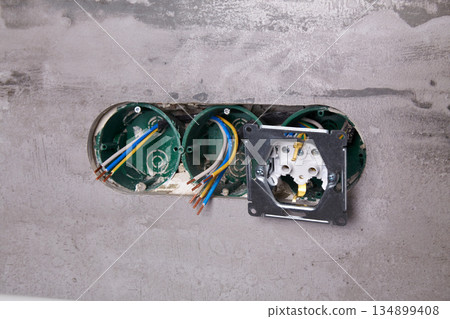 Three electrical boxes for conduits are built into the wall. Work on installing electrical outlets 134899408