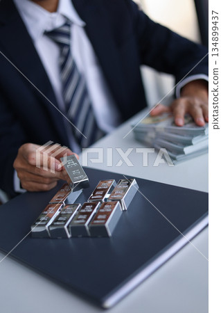 Silver Bars on the table. Businessman invest in trading silver, calculating profit price of buying and selling silver in the market. Silver Bars on the table. Businessman invest in trading silver, calculating profit price of buying and selling silver in the market. 134899437