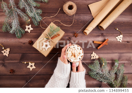 A cup of hot chocolate or cocoa with marshmallows in women's hands. A cup of hot chocolate or cocoa with marshmallows in women's hands. 134899455