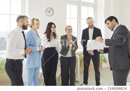 Diverse business happy team stands discussing project at corporate briefing in boardroom 134899624