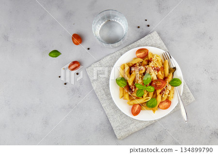 Italian pasta penne with tomatoes, cheese and basil on grey background. 134899790