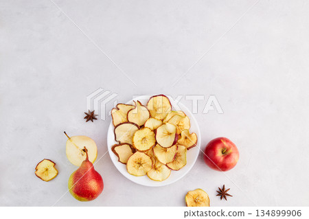 Apple and pear chips on a plate. Homemade fruit dried sliced. 134899906