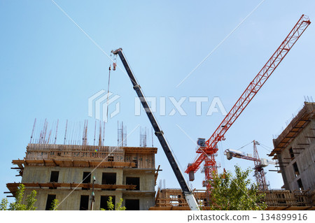 Construction of an apartment building. Cranes on a construction site 134899916