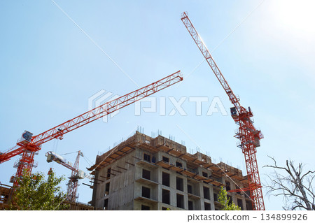 Construction of an apartment building. Cranes on a construction site Construction of an apartment building. Cranes on a construction site 134899926