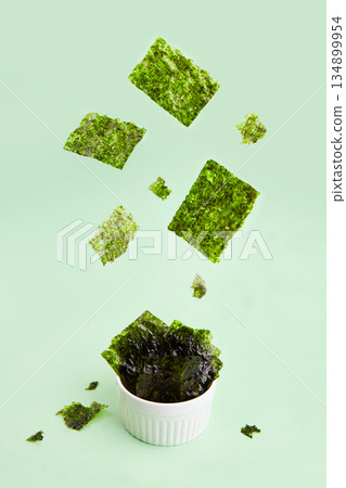 Flying crispy nori seaweed. Traditional Japanese dry seaweed sheets. Flying crispy nori seaweed. Traditional Japanese dry seaweed sheets. 134899954