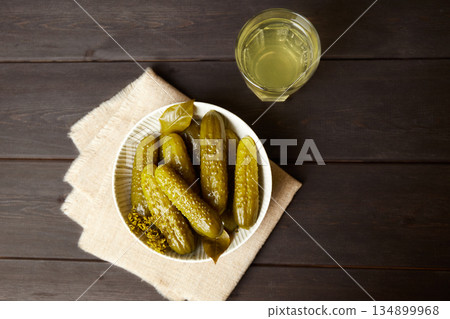 Marinated cucumbers and pickled juice on a dark wooden background. 134899968