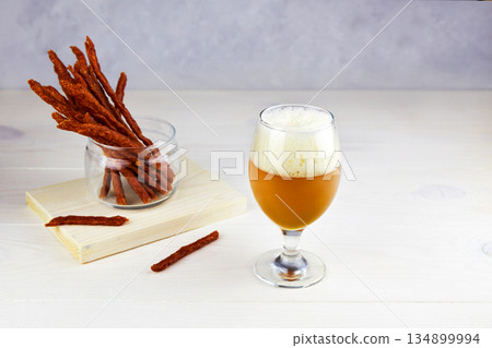 A glass of beer with homemade dried meat sausages A glass of beer with homemade dried meat sausages 134899994