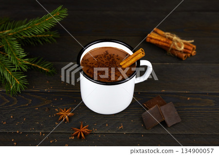 Homemade hot chocolate with cinnamon in a white enamel mug 134900057