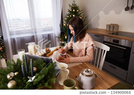 A young girl cooks Christmas gingerbread at home in the kitchen. A young girl cooks Christmas gingerbread at home in the kitchen. 134900068