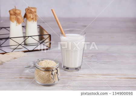 Sesame milk in bottles and a glass, sesame seeds in a jar 134900098