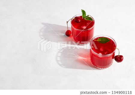 Cherry cocktail with ice on a light grey background. Top view, copy space. Cherry cocktail with ice on a light grey background. Top view, copy space. 134900118