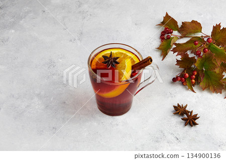 Mulled wine with slice of orange and spices. Autumn drink or gluhwein. 134900136