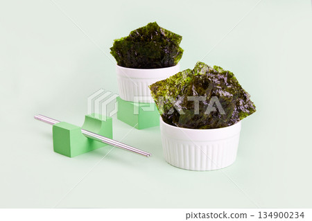 Crispy nori seaweed on bowl. Traditional Japanese dry seaweed sheets. 134900234