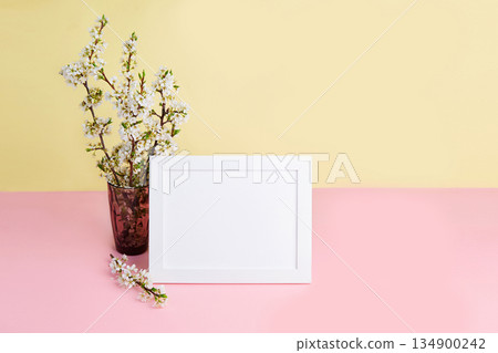 A bouquet of flowering plum branches in a vase and a photo frame A bouquet of flowering plum branches in a vase and a photo frame 134900242