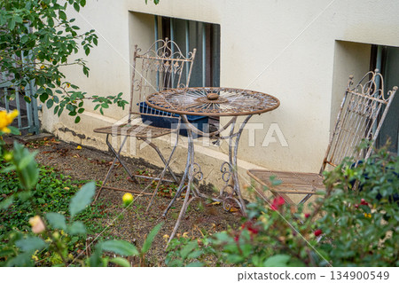 Metal garden furniture. Old table and chairs near house Metal garden furniture. Old table and chairs near house 134900549