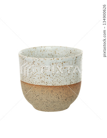 Handmade ceramic cup with speckled glaze, two-tone beige and white design. Minimalist stoneware mug isolated on white background. Handmade ceramic cup with speckled glaze, two-tone beige and white design. Minimalist stoneware mug isolated on white background. 134900626