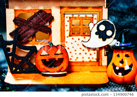 Cardboard house and Pumpkin carved into spooky demon face for halloween Cardboard house and Pumpkin carved into spooky demon face for halloween 134900746
