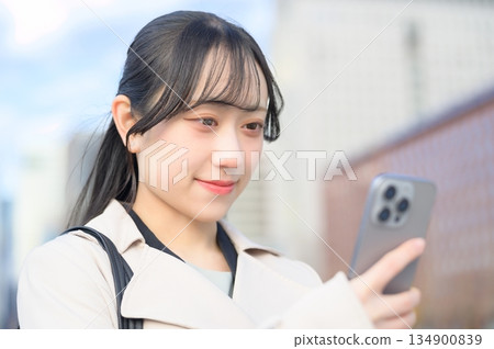 一名日本女子在辦公區使用智慧型手機 一名日本女子在辦公區使用智慧型手機 134900839