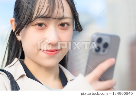 Japanese woman using a smartphone in an office district Japanese woman using a smartphone in an office district 134900840