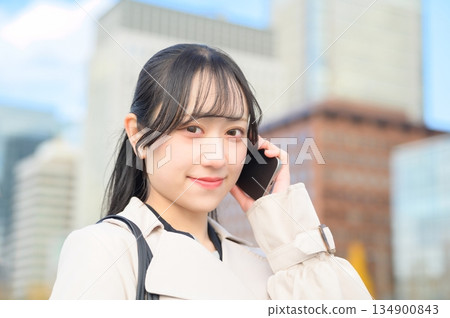 Japanese woman using a smartphone in an office district Japanese woman using a smartphone in an office district 134900843