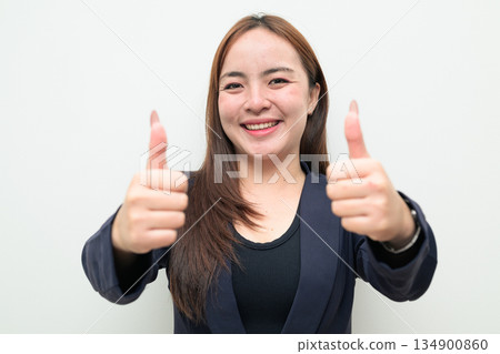 Portrait of Asian businesswoman against white background giving thumbs up approval with both hands 134900860