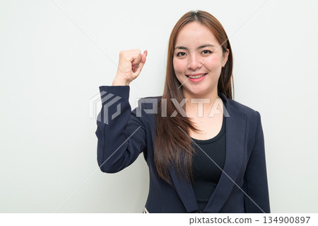Portrait of a young Asian businesswoman against white background celebrating with arms raised up Portrait of a young Asian businesswoman against white background celebrating with arms raised up 134900897