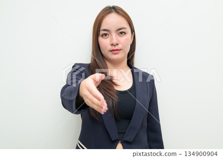Portrait of a young Asian businesswoman against white background reaching out hand for handshake Portrait of a young Asian businesswoman against white background reaching out hand for handshake 134900904