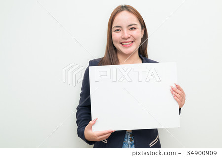 Portrait of young Asian businesswoman against white background showing copy space from white board 134900909