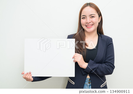 Portrait of young Asian businesswoman against white background showing copy space from white board 134900911