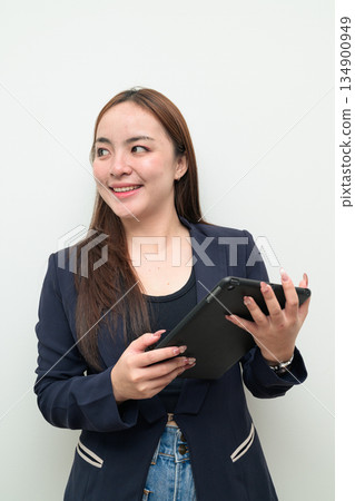 Portrait of a young Asian businesswoman against white background using digital tablet computer Portrait of a young Asian businesswoman against white background using digital tablet computer 134900949