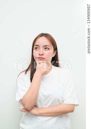 Portrait of a young Asian woman against white background thinking Portrait of a young Asian woman against white background thinking 134900987