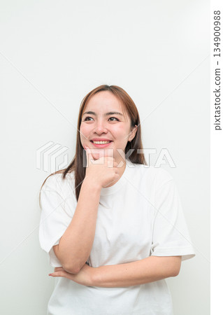 Portrait of a young Asian woman against white background smiling and thinking Portrait of a young Asian woman against white background smiling and thinking 134900988