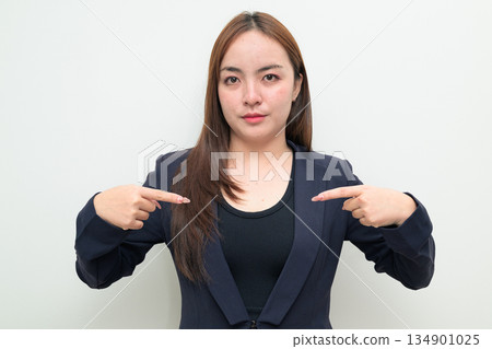 Portrait of a young Asian businesswoman against white background pointing at self confidently Portrait of a young Asian businesswoman against white background pointing at self confidently 134901025