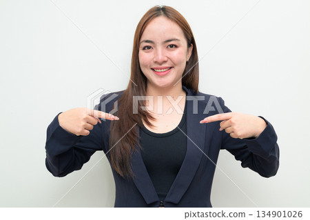Portrait of a young Asian businesswoman against white background pointing at self with smile 134901026
