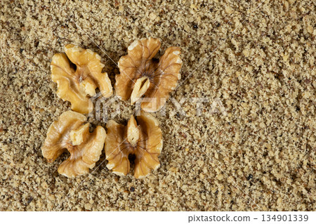 Walnut halves on ground walnut kernels background top view place for text Walnut halves on ground walnut kernels background top view place for text 134901339
