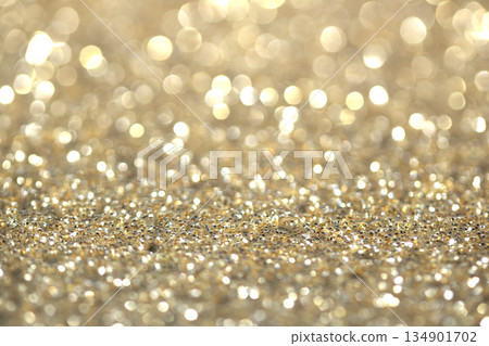 Gold shimmer glitter background with focus and bokeh Gold shimmer glitter background with focus and bokeh 134901702