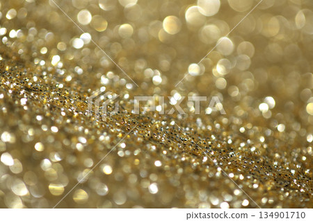 Gold shimmer glitter background with focus and bokeh Gold shimmer glitter background with focus and bokeh 134901710