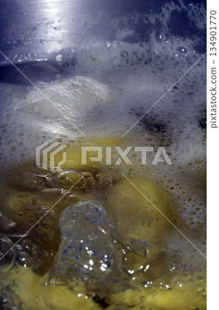 Close up of boiling water with potatoes being cooked 134901770