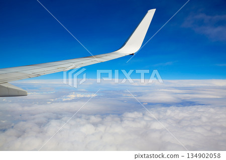 Aircraft wing flying in blue sky and clouds 134902058