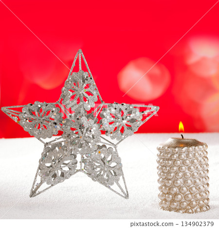 Christmas card of silver star and candle on snow Christmas card of silver star and candle on snow 134902379