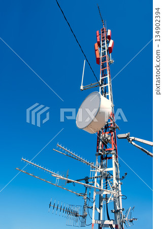 Antenna repeater messy mast in blue sky Antenna repeater messy mast in blue sky 134902394