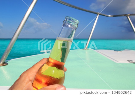 beer on hand Caribbean in boat bow turquoise sea beer on hand Caribbean in boat bow turquoise sea 134902642