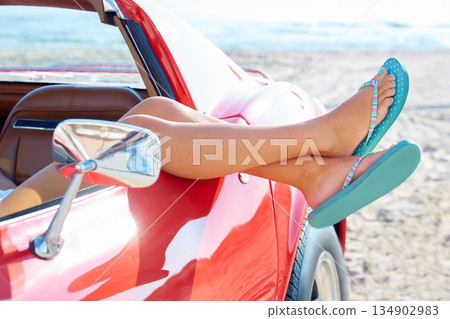 Relaxed woman legs in a car window on the beach 134902983