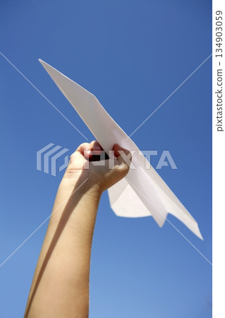 Paper airplane in children hand over blue sky Paper airplane in children hand over blue sky 134903059